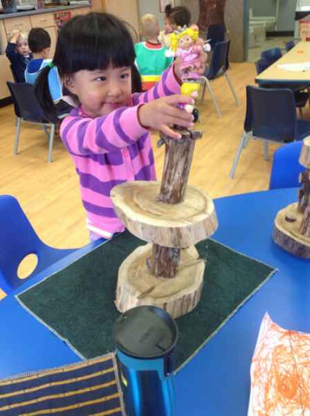 girl concentrating while stacking wood pieces